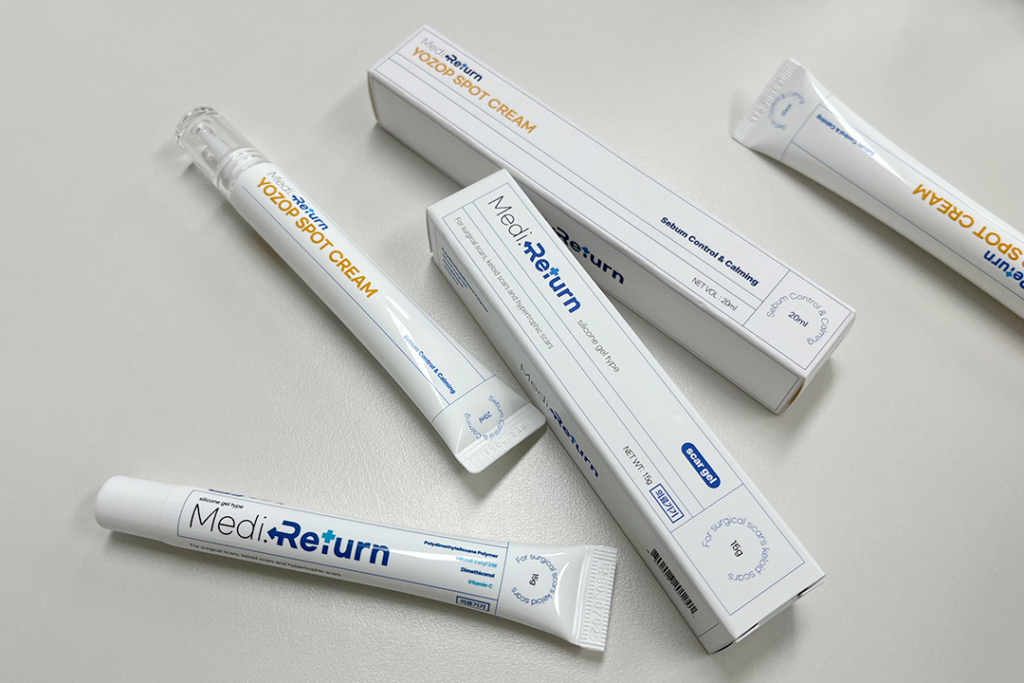 흉터 케어를 위한 메디리턴겔 흉리무버와 국소 부위 진정에 탁월한 요좁크림의 본품 튜브와 단상자가 정갈하게 놓여 있는 최종 제품