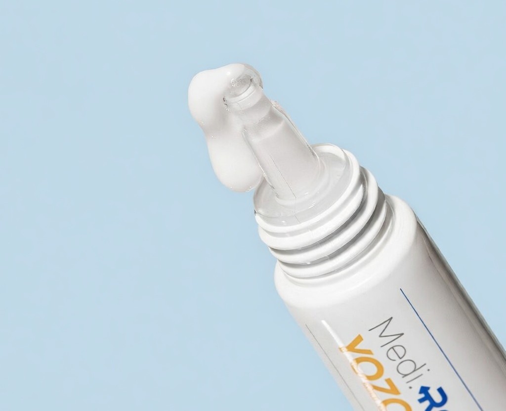 요좁 크림 사용 직전 장면: 튜브 끝에서 크림이 정갈하게 배출되는 모습, 빠른 흡수와 정밀 도포를 위한 롤온 타입 제품 강조