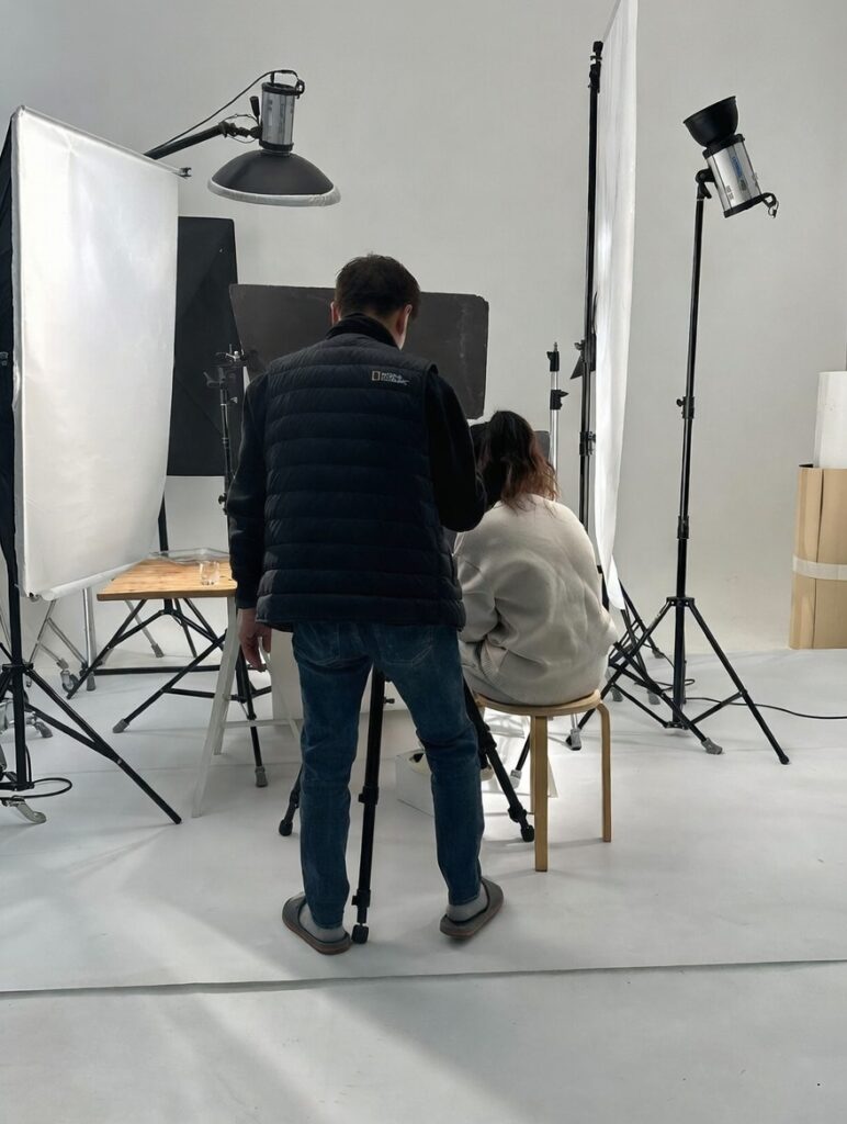 전문 촬영 기사와 스태프가 조명 아래 놓인 스킨케어 제품의 베스트 컷을 담기 위해 집중하고 있는 뒷모습입니다. 작은 디테일 하나 놓치지 않으려는 메디리턴의 꼼꼼한 브랜드 철학이 담긴 현장 사진입니다.